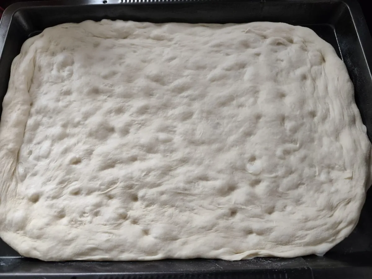Pizzadeeg dat rijst in een bak