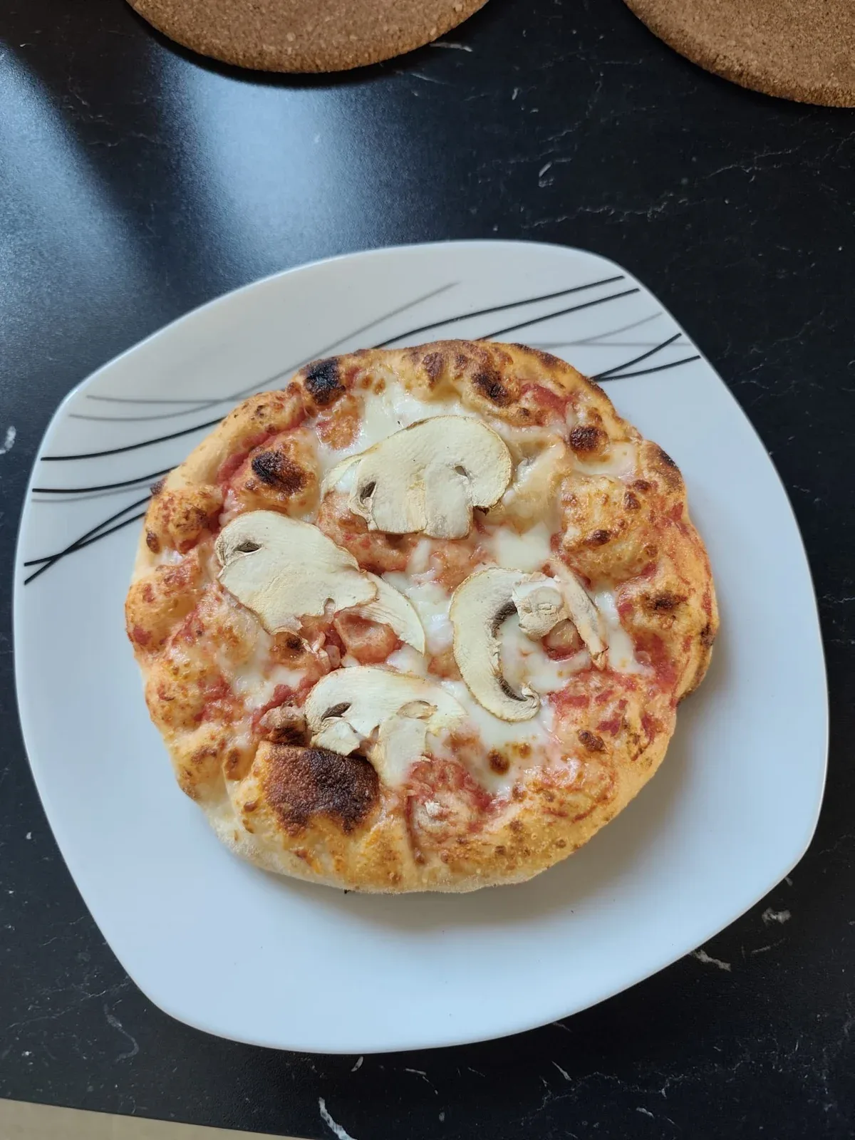 Een pizza met champignons op tafel