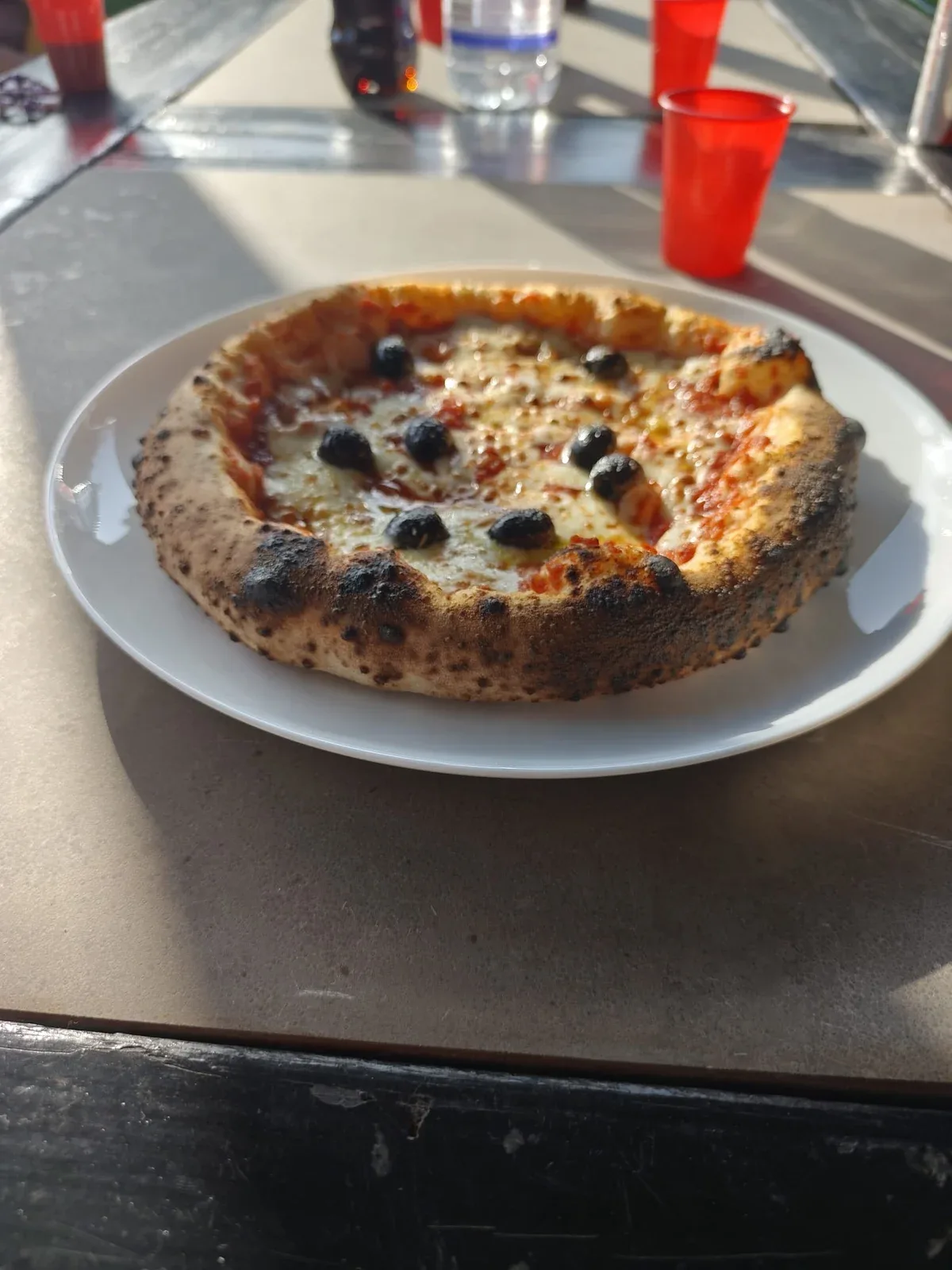 Een Napolitaanse pizza met olijven, vers uit de oven